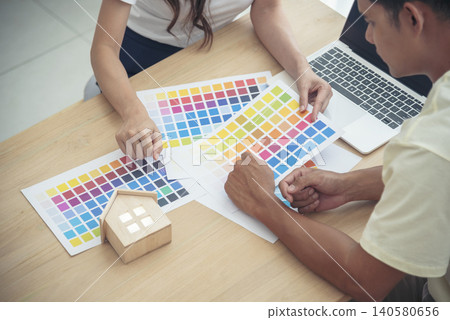 Asian interior designer team partner engineer brainstorming choosing color swatch. Engineer man Contractor brainstorming teams partner meeting together in office desk. Paint palette architecture plan Asian interior designer team partner engineer brainstorming choosing color swatch. Engineer man Contractor brainstorming teams partner meeting together in office desk. Paint palette architecture plan 140580656