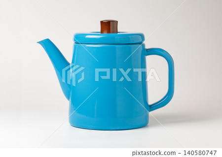 A blue enamel kettle against a white background. 140580747