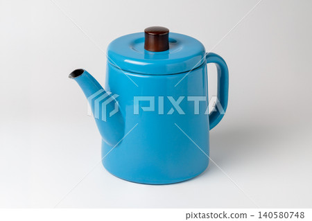 A diagonal composition of a blue enamel kettle against a white background. 140580748