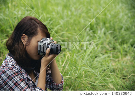 Close up hands Asian Women look at dslr digital camera vintage film style take a photo. Professional female photographer look at picture outdoor. Young woman hands shooting photo in green nature park Close up hands Asian Women look at dslr digital camera vintage film style take a photo. Professional female photographer look at picture outdoor. Young woman hands shooting photo in green nature park 140580943