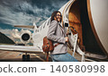 Luxury business travel executive woman boarding private jet airplane on airport tarmac 140580998