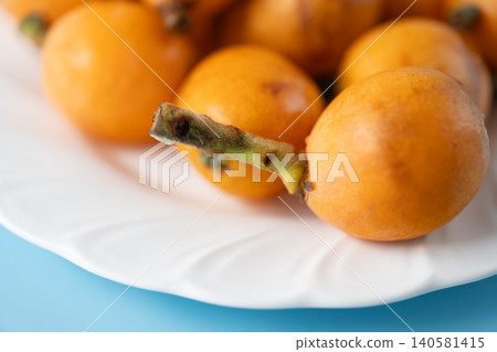 Irregularly shaped, organic, ripe loquats as background material | Natural imperfections and discoloration remain. Irregularly shaped, organic, ripe loquats as background material | Natural imperfections and discoloration remain. 140581415