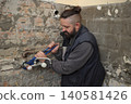 Plumber fixing old tap in a bathroom using adjustable wrench 140581426