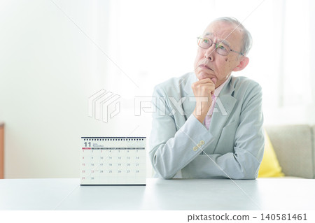 一位老人正在看日曆。 一位老人正在看日曆。 140581461