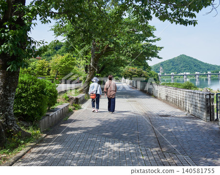 夏日清晨，幾位老年婦女沿著犬山市木曾川河畔步道散步。 140581755