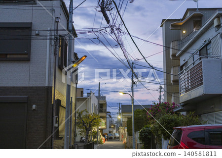 Oji, Kita Ward: A residential street scene at dusk, illuminated by a dimly lit streetlamp. 140581811
