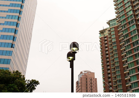 A cityscape with high-rise apartments and streetlights. 140581986