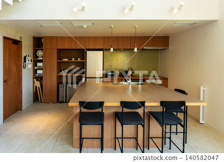 A spacious island kitchen with a stylish wood-grain finish. 140582047