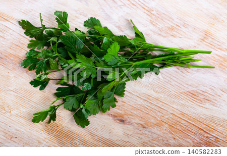 Fresh green parsley leaves on wooden desk Fresh green parsley leaves on wooden desk 140582283