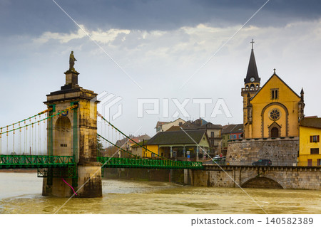 Seyssel embankment on Rhone river with Saint-Blaise church and suspension bridge in winter Seyssel embankment on Rhone river with Saint-Blaise church and suspension bridge in winter 140582389