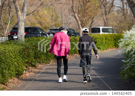A middle school boy and his parents strolling in a park in spring. A middle school boy and his parents strolling in a park in spring. 140582405