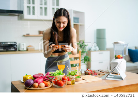 Asian fitness woman vlogging healthy food recipe kitchen 140582721