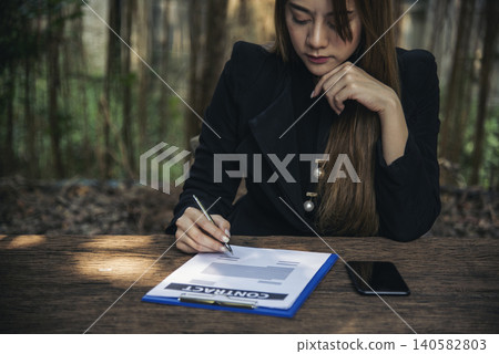 Woman hands writing empty notebook planing meeting agenda on wooden table. Close up women hands using pen drinking coffee cup planning office paper. Female hand holding pen note Personal Organizer Woman hands writing empty notebook planing meeting agenda on wooden table. Close up women hands using pen drinking coffee cup planning office paper. Female hand holding pen note Personal Organizer 140582803