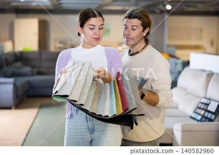 Man and woman picking upholstery materials in furniture store Man and woman picking upholstery materials in furniture store 140582960