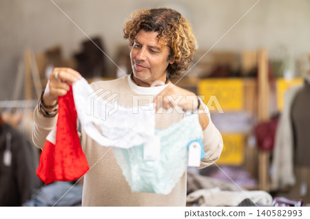 Man search and choose ladys lace panties in store 140582993