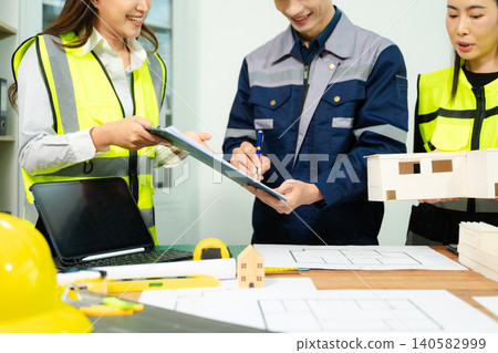 Engineer desk with object paper and tablet with blurry engineer teamwork hardworking to consults about their building project. 140582999
