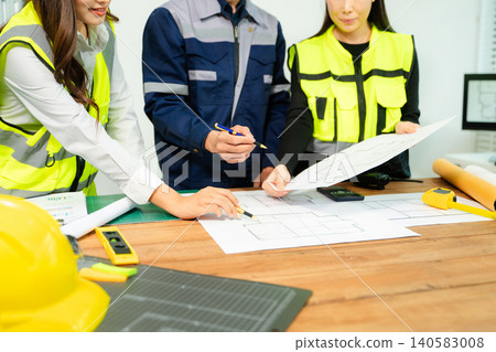 Creative architect projecting on the big drawings with architectural project at construction site at desk 140583008