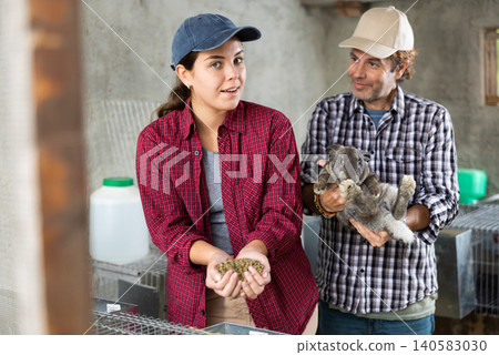 Family business - man and woman breed rabbits on farm 140583030