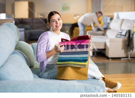 girl on the sofa infurniture store decides what fabric to choose girl on the sofa infurniture store decides what fabric to choose 140583131