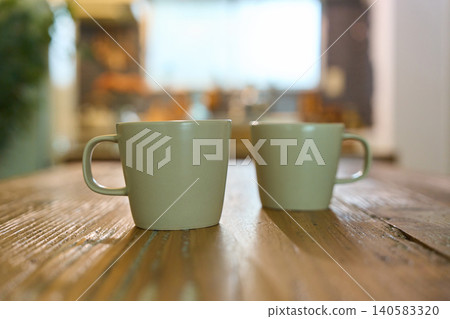 Two mugs lined up on the table in the room Two mugs lined up on the table in the room 140583320