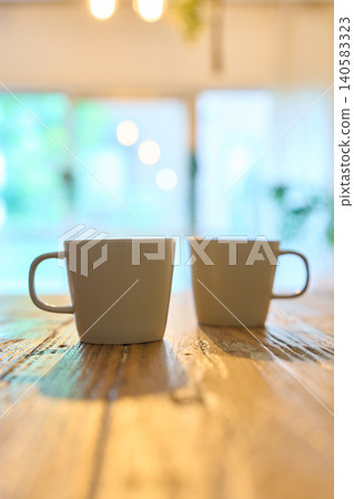 Two mugs lined up on the table in the room Two mugs lined up on the table in the room 140583323