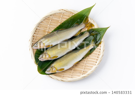 一條香魚放在白色背景上的竹籃裡。 140583331