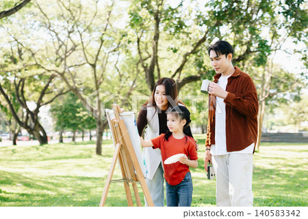 Happy family painting together outdoors in a sunny green park. A joyful lifestyle moment filled with creativity, learning, love, and togetherness. Happy family painting together outdoors in a sunny green park. A joyful lifestyle moment filled with creativity, learning, love, and togetherness. 140583342
