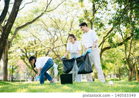 Joyful family volunteering to clean up a green park together. A positive lifestyle scene promoting eco-awareness, teamwork, and love for nature. Joyful family volunteering to clean up a green park together. A positive lifestyle scene promoting eco-awareness, teamwork, and love for nature. 140583349