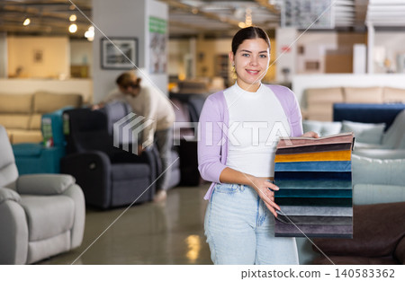 Female seller offers a choice of fabrics for furniture Female seller offers a choice of fabrics for furniture 140583362