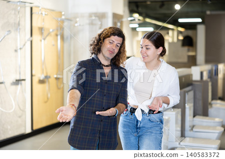 Husband and wife shopping for bathroom furnishings together in hardware store Husband and wife shopping for bathroom furnishings together in hardware store 140583372