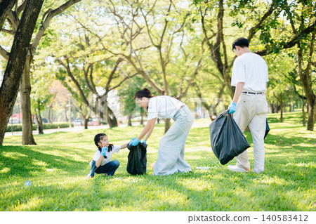 Joyful family volunteering to clean up a green park together. A positive lifestyle scene promoting eco-awareness, teamwork, and love for nature. Joyful family volunteering to clean up a green park together. A positive lifestyle scene promoting eco-awareness, teamwork, and love for nature. 140583412