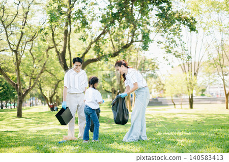 Joyful family volunteering to clean up a green park together. A positive lifestyle scene promoting eco-awareness, teamwork, and love for nature. Joyful family volunteering to clean up a green park together. A positive lifestyle scene promoting eco-awareness, teamwork, and love for nature. 140583413