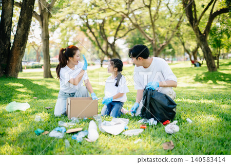 Joyful family volunteering to clean up a green park together. A positive lifestyle scene promoting eco-awareness, teamwork, and love for nature. Joyful family volunteering to clean up a green park together. A positive lifestyle scene promoting eco-awareness, teamwork, and love for nature. 140583414