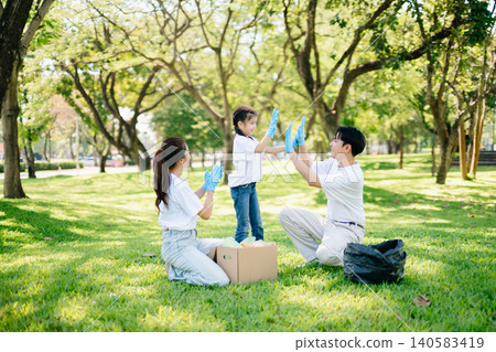 Joyful family volunteering to clean a park together. A heartwarming outdoor scene promoting teamwork, love, and environmental awareness in a green lifestyle. Joyful family volunteering to clean a park together. A heartwarming outdoor scene promoting teamwork, love, and environmental awareness in a green lifestyle. 140583419
