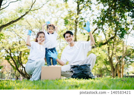 Joyful family volunteering to clean a park together. A heartwarming outdoor scene promoting teamwork, love, and environmental awareness in a green lifestyle. Joyful family volunteering to clean a park together. A heartwarming outdoor scene promoting teamwork, love, and environmental awareness in a green lifestyle. 140583421