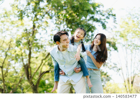 Joyful family playing together in a sunny green park. A candid outdoor moment full of love, laughter, and connection Joyful family playing together in a sunny green park. A candid outdoor moment full of love, laughter, and connection 140583477