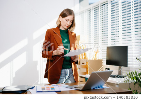 Designer selecting color palette while working on a creative branding project in a modern bright workspace. 140583810