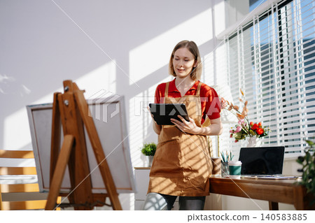 A focused female artist holding her coffee while sketching ideas in her sunlit studio, capturing creativity, peaceful workflow, and an inspiring artistic routine. A focused female artist holding her coffee while sketching ideas in her sunlit studio, capturing creativity, peaceful workflow, and an inspiring artistic routine. 140583885