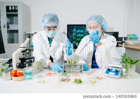 Dynamic scene of food scientists using microscopes and pipettes in a lab Dynamic scene of food scientists using microscopes and pipettes in a lab 140583960