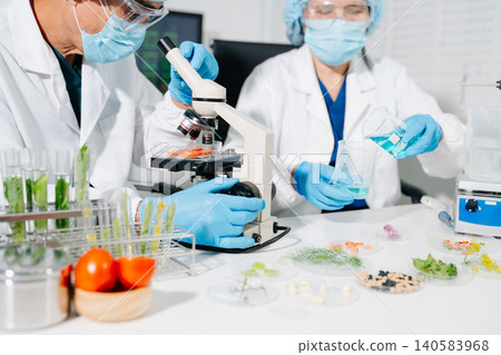 Dynamic scene of food scientists using microscopes and pipettes in a lab Dynamic scene of food scientists using microscopes and pipettes in a lab 140583968