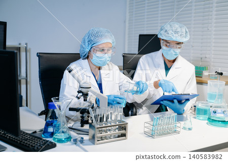 Scientists working together in laboratory analyzing samples and data on digital screen, representing medical research, biotechnology innovation Scientists working together in laboratory analyzing samples and data on digital screen, representing medical research, biotechnology innovation 140583982