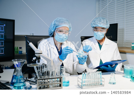 Scientists working together in laboratory analyzing samples and data on digital screen, representing medical research, biotechnology innovation Scientists working together in laboratory analyzing samples and data on digital screen, representing medical research, biotechnology innovation 140583984