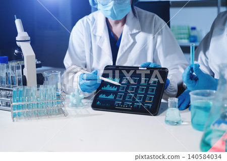 Scientists performing medical laboratory research using DNA analysis, biotechnology technology, microscope testing and digital healthcare data 140584034