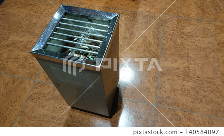 A stylish stainless steel stand ashtray placed on the floor. A stylish stainless steel stand ashtray placed on the floor. 140584097
