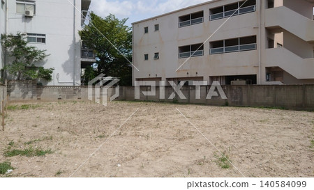 A vast, leveled vacant lot and empty plot of land stretching out at the back of a residential area. 140584099