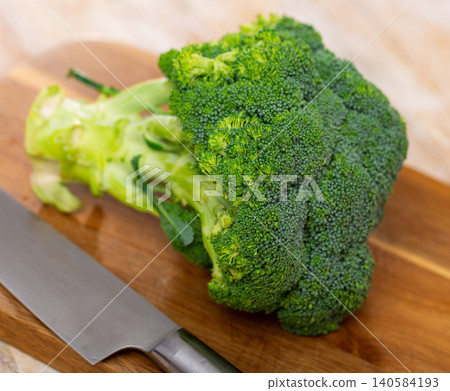 Cutting and cooking green broccoli on wooden textured backdrop Cutting and cooking green broccoli on wooden textured backdrop 140584193