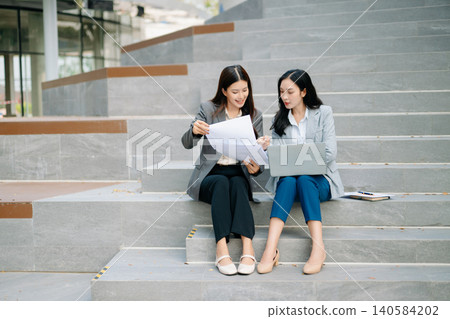 Business woman team going in city center in smart casual business style, talking, working together, stylish freelance people, holding coffee and laptop,tablet and smartphone Business woman team going in city center in smart casual business style, talking, working together, stylish freelance people, holding coffee and laptop,tablet and smartphone 140584202