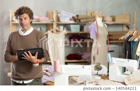 Man tailor makes pattern using tablet Man tailor makes pattern using tablet 140584221