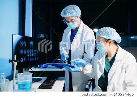 Medical scientists conducting laboratory research using digital tools and lab equipment. Healthcare, biotechnology, diagnostics, and clinical research teamwork concept. Medical scientists conducting laboratory research using digital tools and lab equipment. Healthcare, biotechnology, diagnostics, and clinical research teamwork concept. 140584460