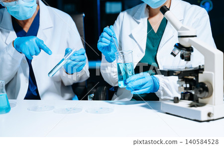 Medical scientists working in laboratory, analyzing test tube samples during research and experiment, reflecting healthcare, science, teamwork 140584528